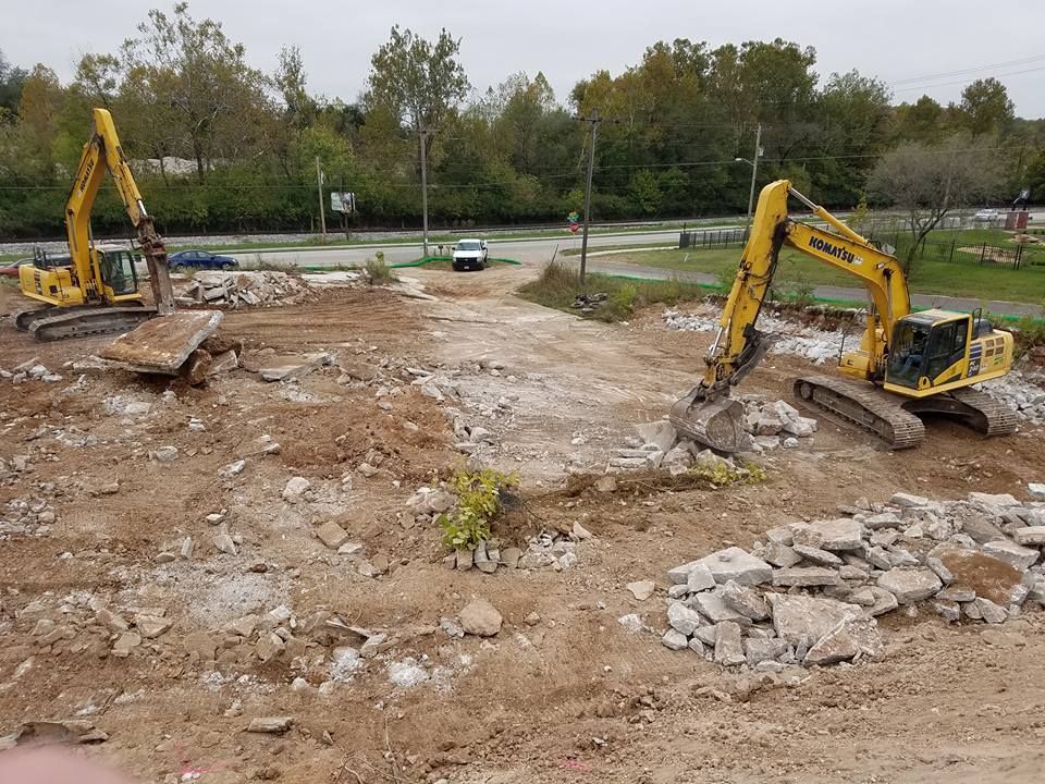 Two yellow excavators are working on a construction site.