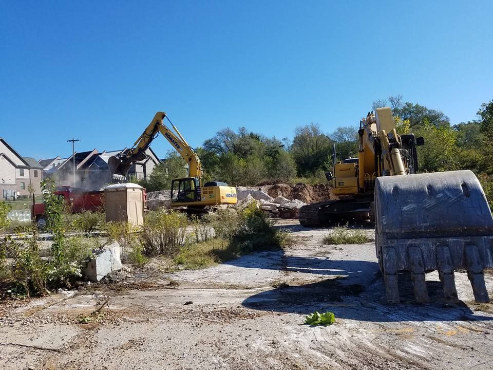 A group of construction vehicles are working on a construction site.