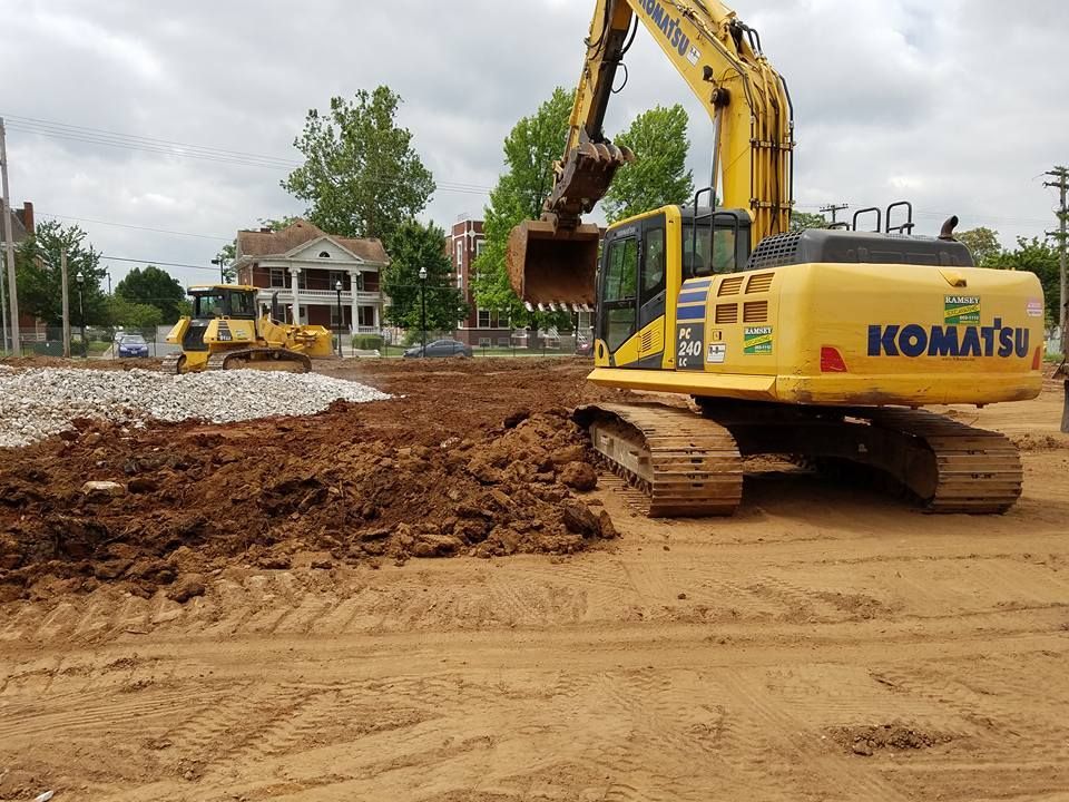 A komatsu excavator is digging in a dirt field