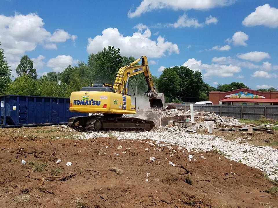A yellow komatsu excavator is working on a construction site.