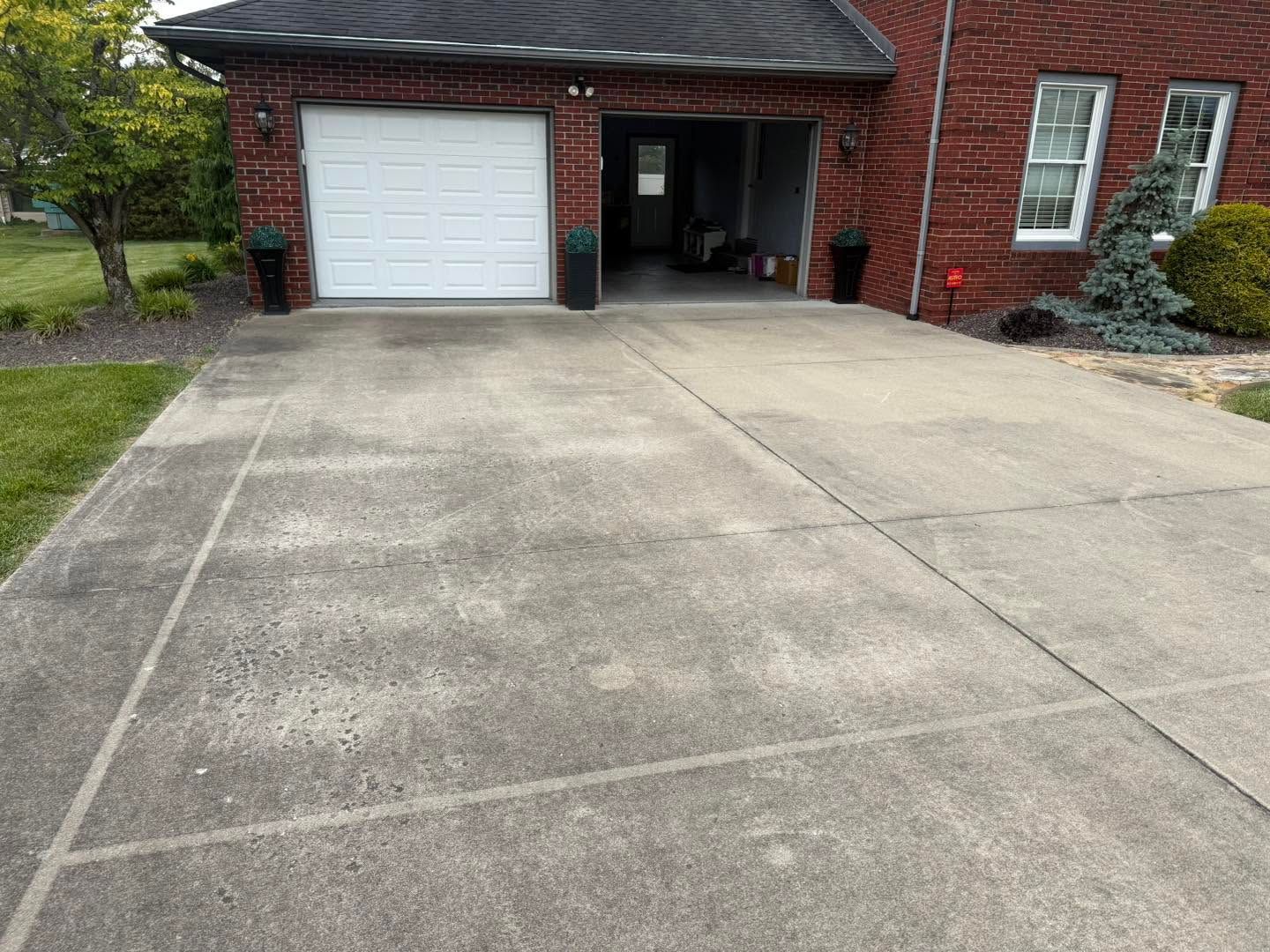 Driveway leading to a brick house with a white garage door and front entrance