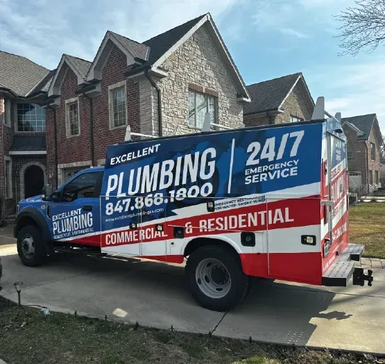 A plumbing truck is parked in front of a house