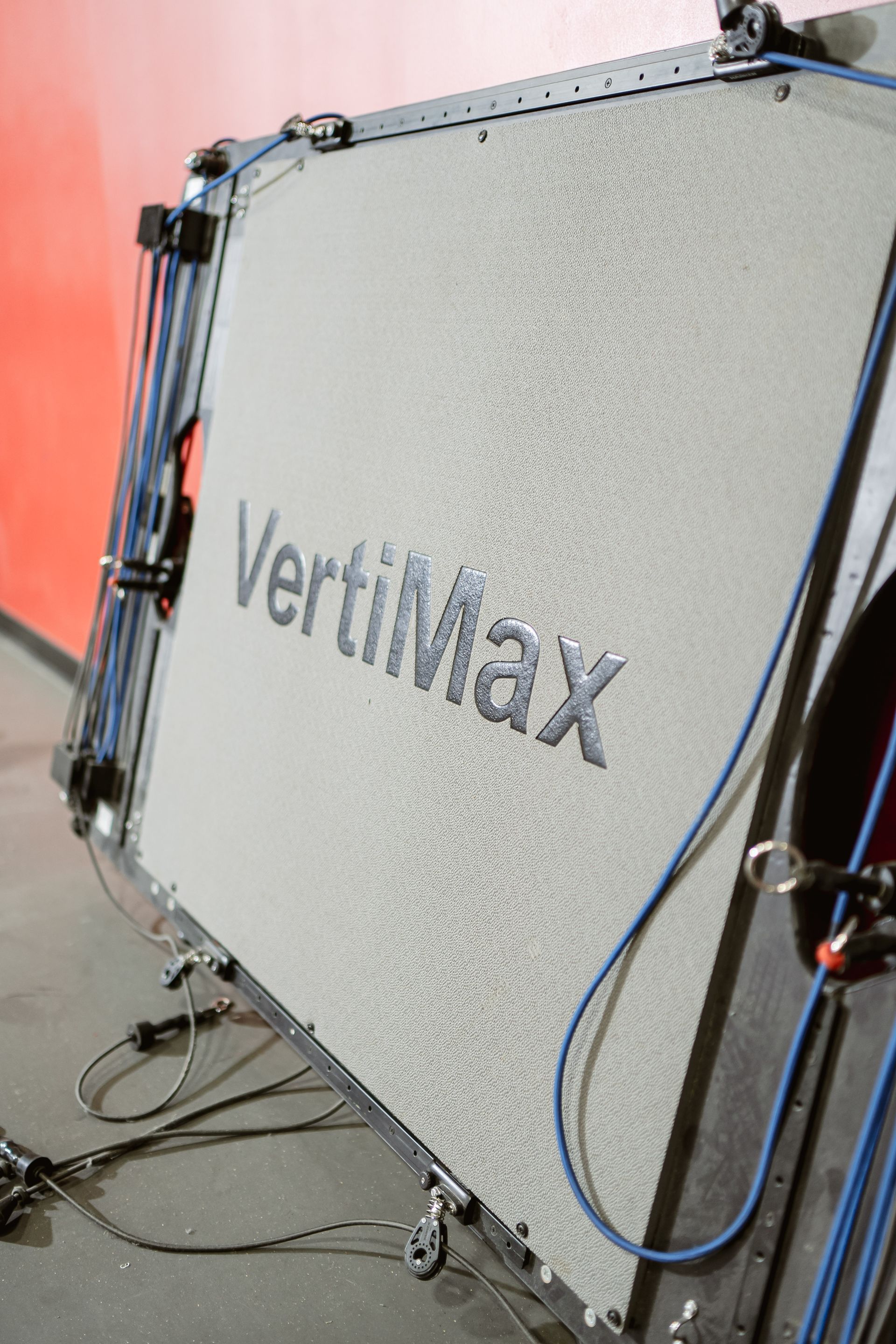 VertiMax training equipment with gray panel and metal frame, cables attached, on a studio floor