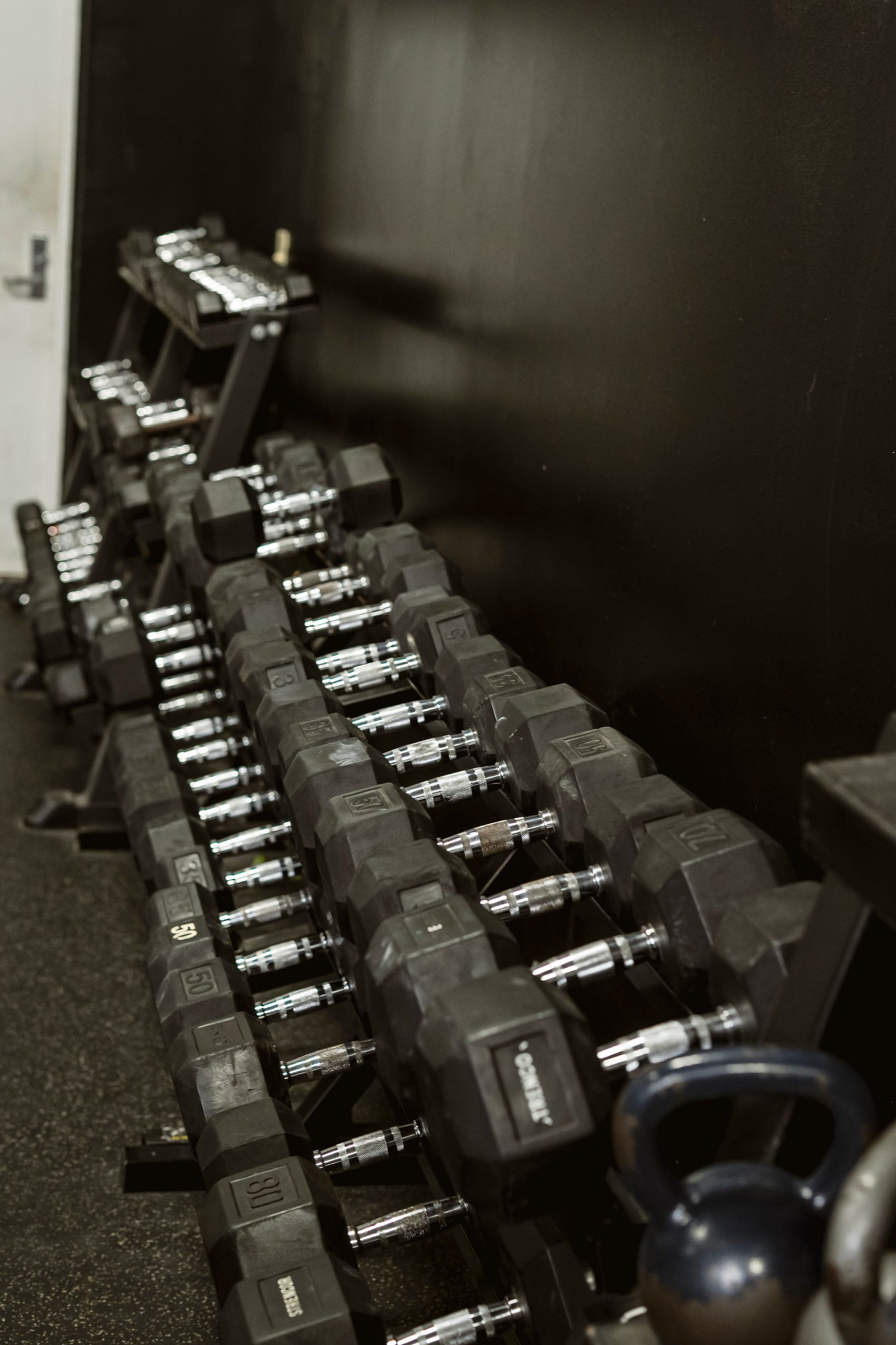 Row of dumbbells on a rack in a dim gym or storage area