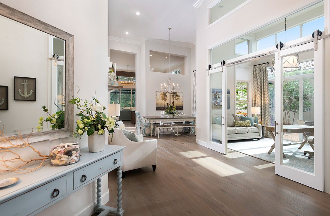Kitchen with stainless steel appliances, granite countertop, pendant lights, and light wood barn door.