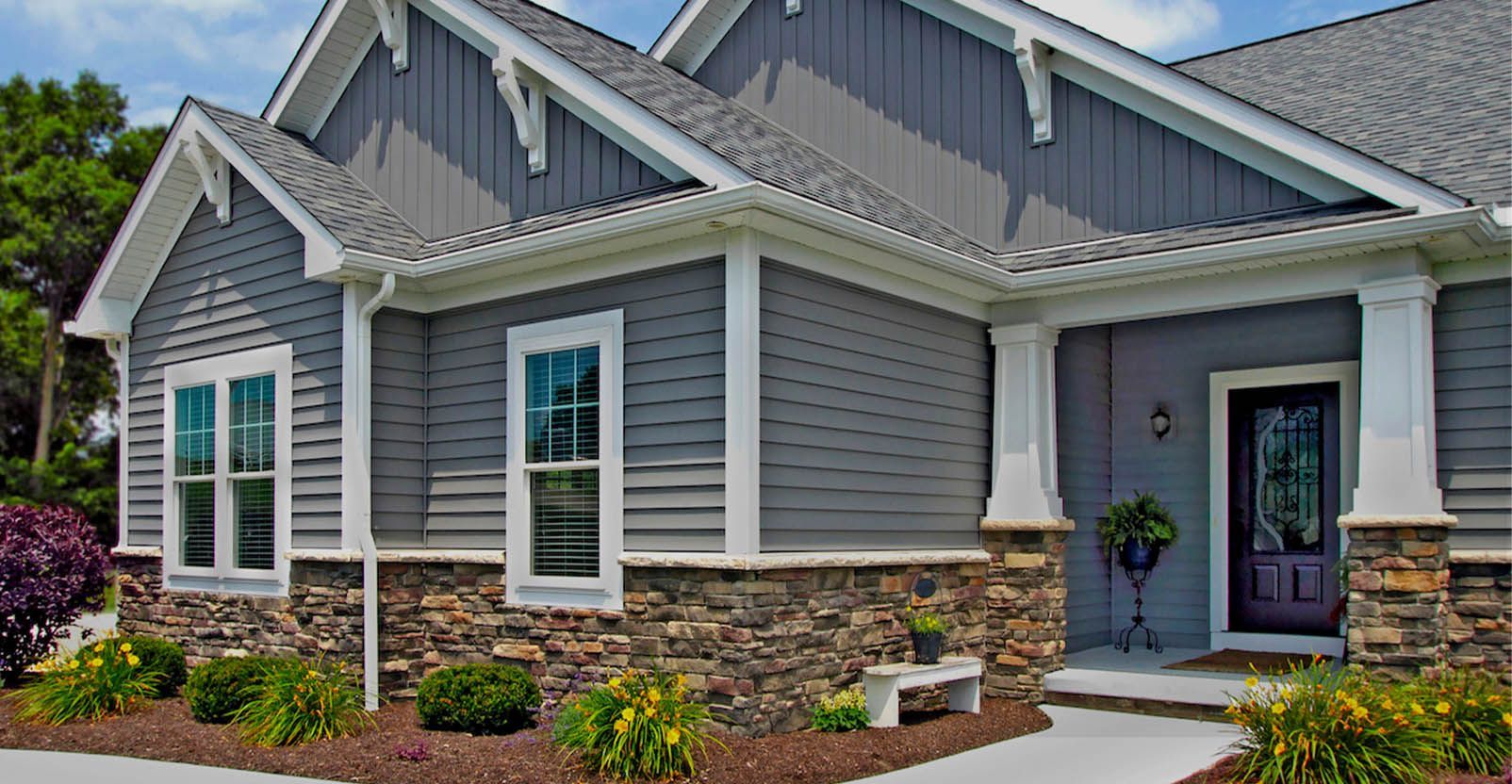 Light blue house with white-framed windows, surrounded by snow. A section has a low roof.