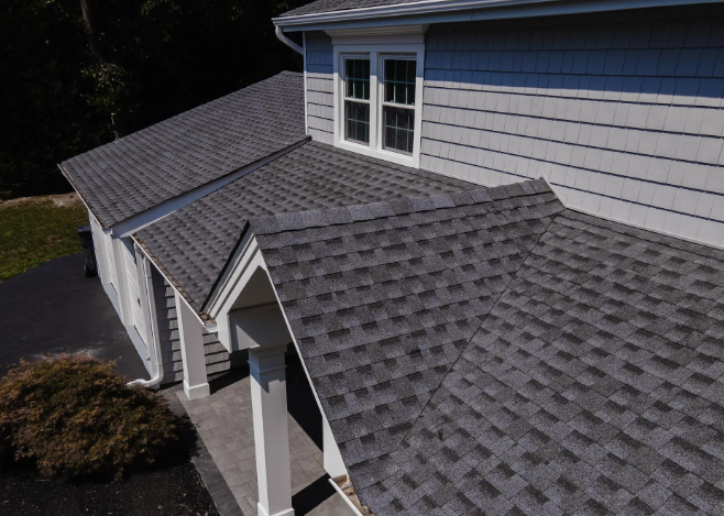 Gray asphalt shingle roof on a house with gray siding and white trim.