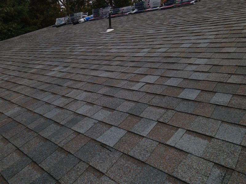 Asphalt shingle roof with mixed brown and gray tones, slightly weathered.