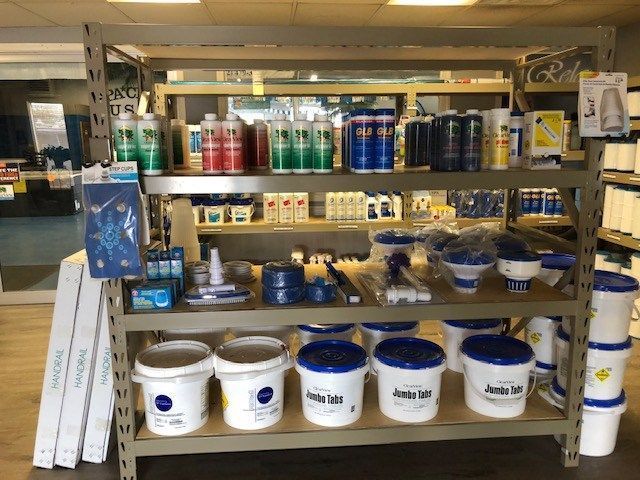 Shelves stocked with pool chemicals and supplies in a store.