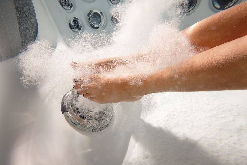 Feet in a bubbly hot tub, with jets visible.