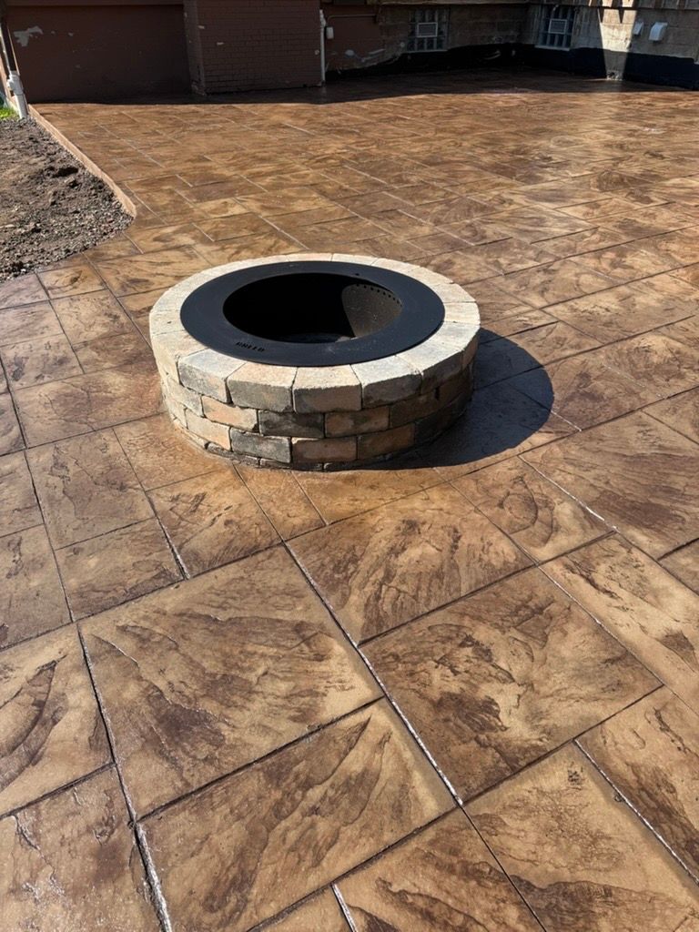 Stone fire pit in a stamped concrete patio area