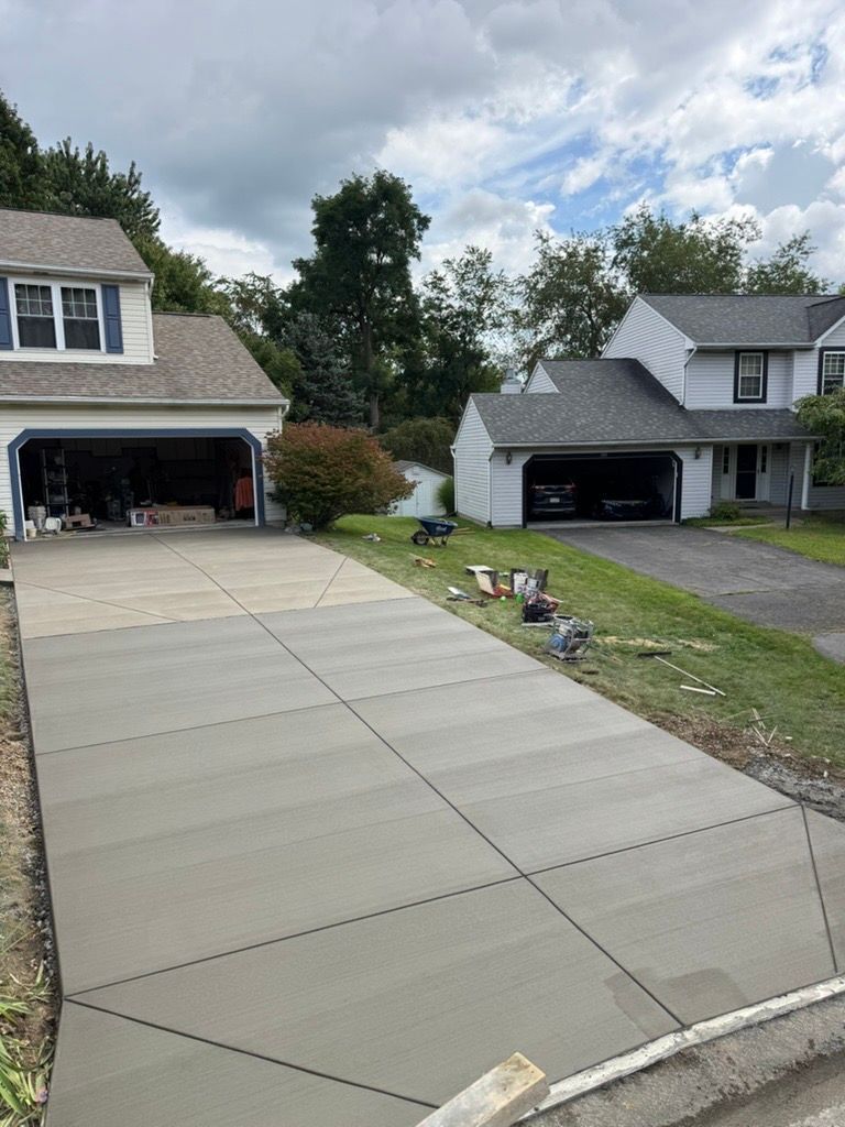 Residential driveway leading to two garage houses under a cloudy sky
