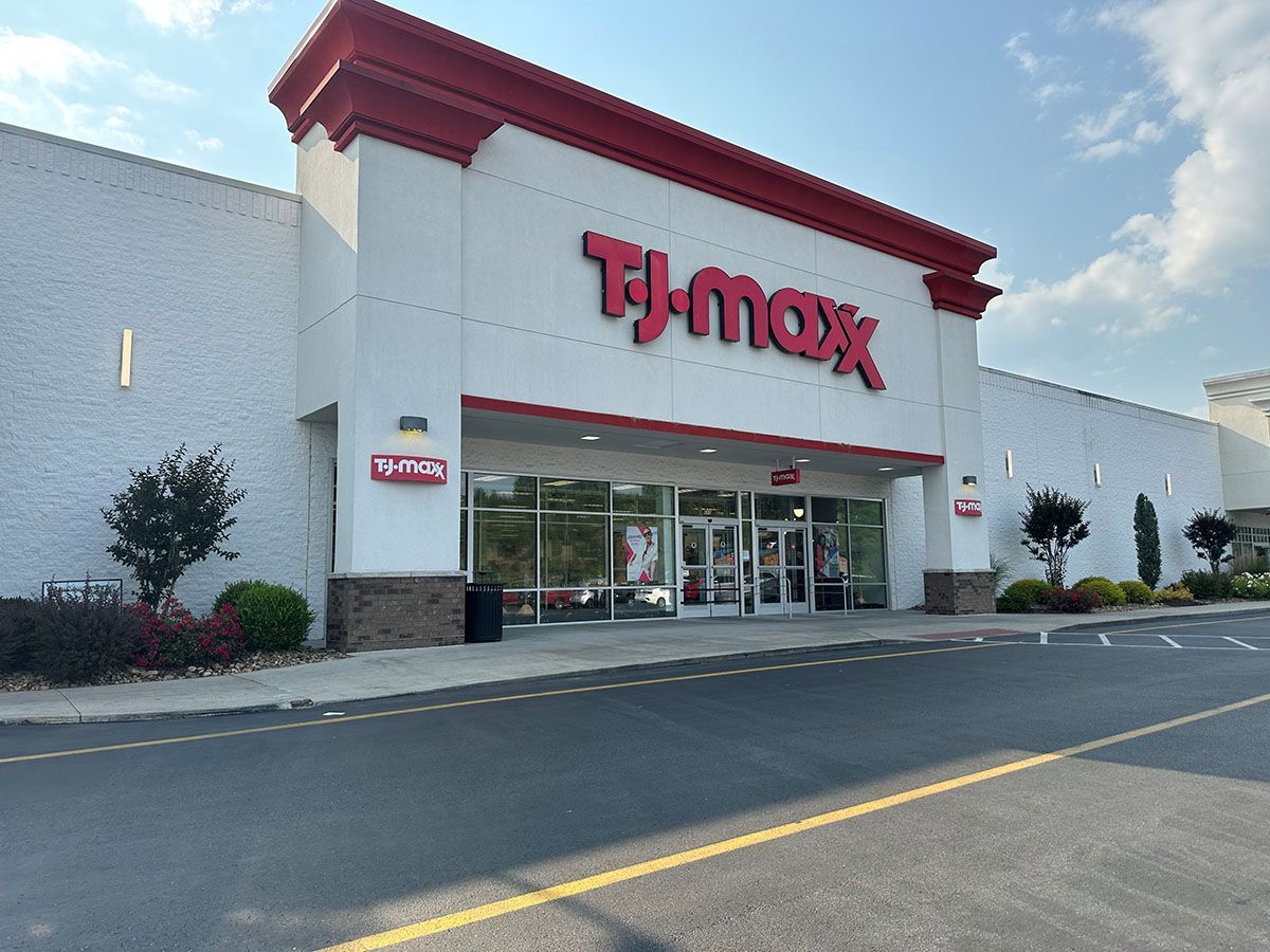 The front of a t-max store with a parking lot in front of it.