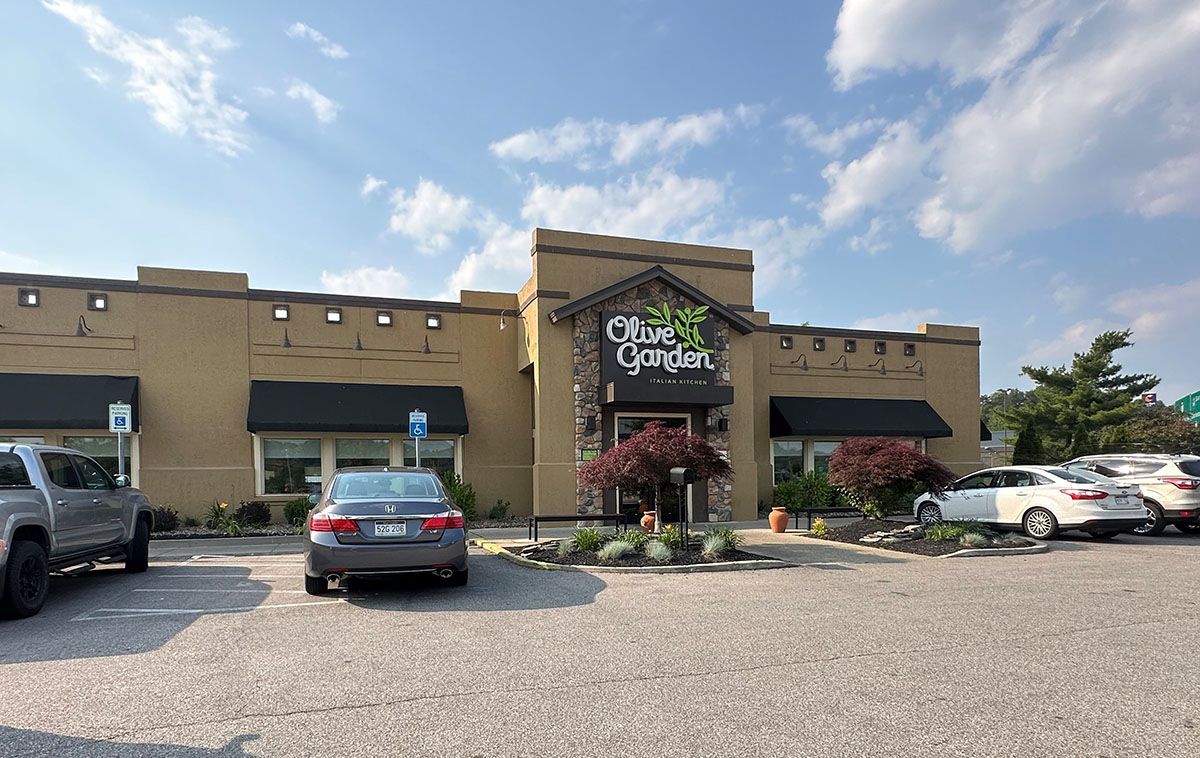 A large building with a lot of cars parked in front of it.