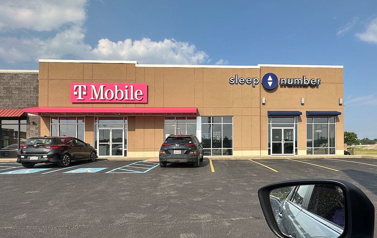 A car is parked in front of a t mobile store.