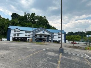 A large blue and white building with a parking lot in front of it
