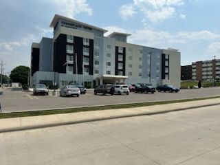 A large building with a lot of cars parked in front of it