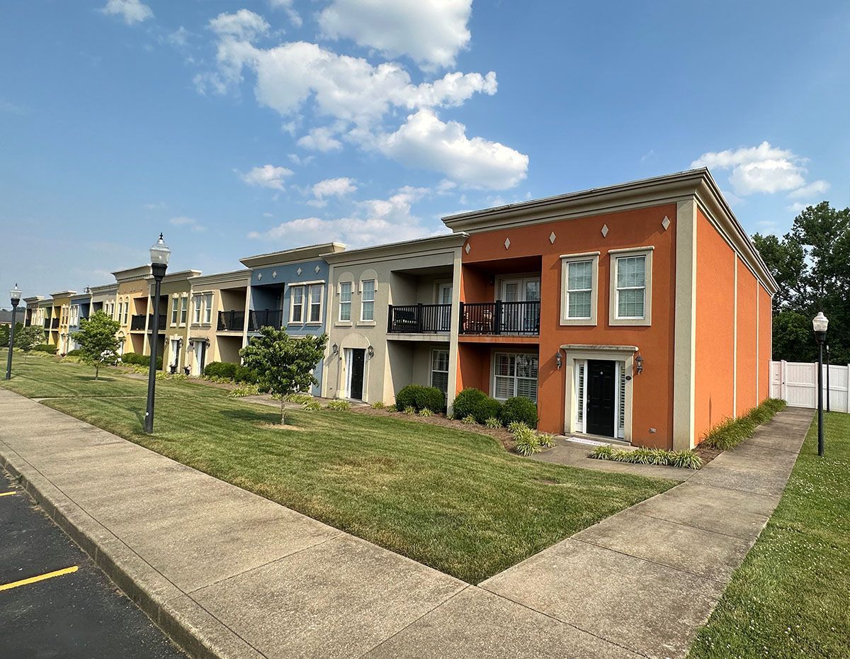 A row of apartment buildings sitting next to each other on a sunny day.