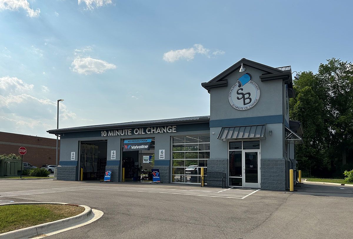 A car wash is located in the middle of a parking lot.