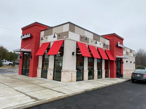 A restaurant with red awnings on the windows