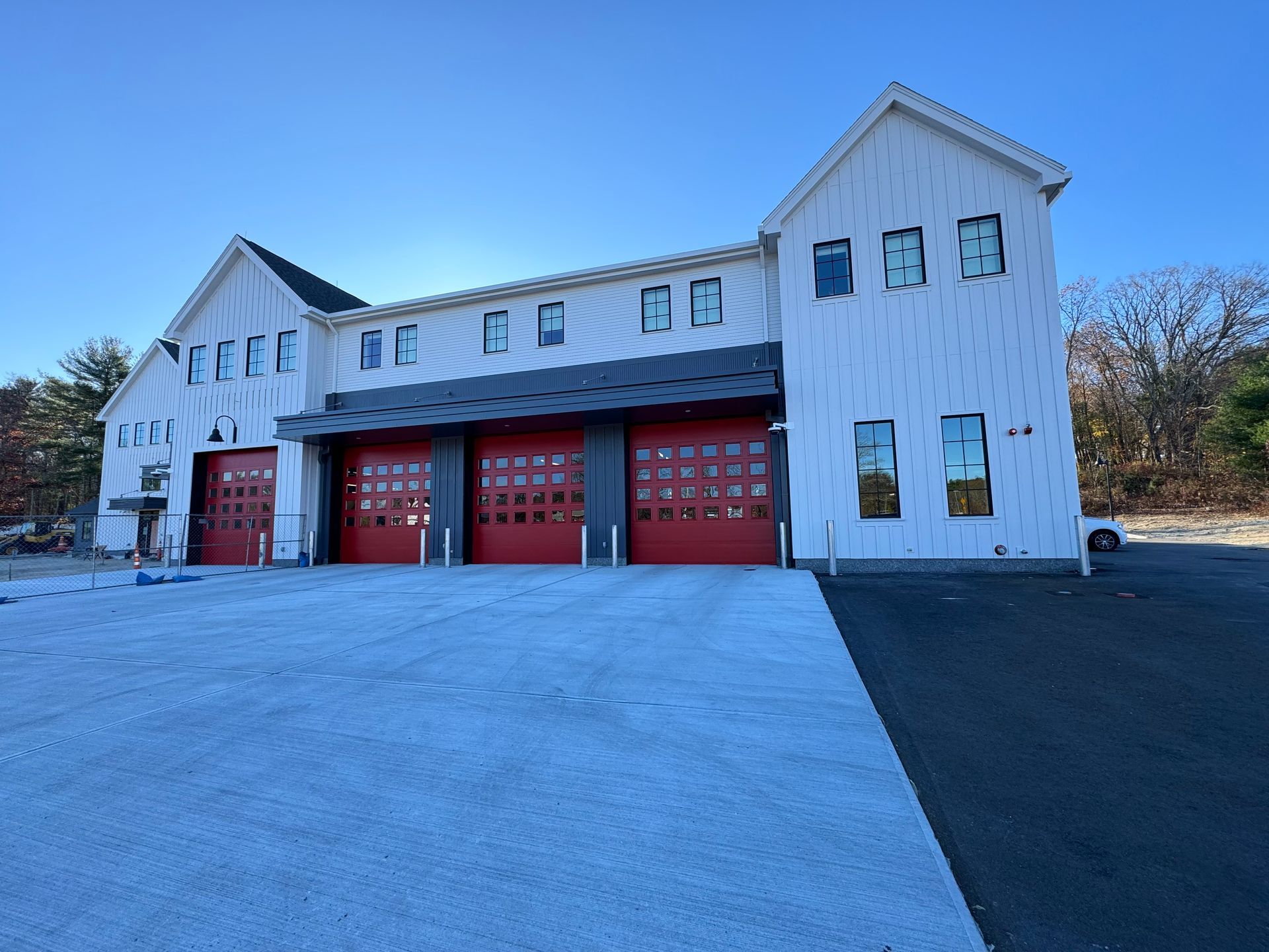 A white building with red garage doors and a blue sky in the background