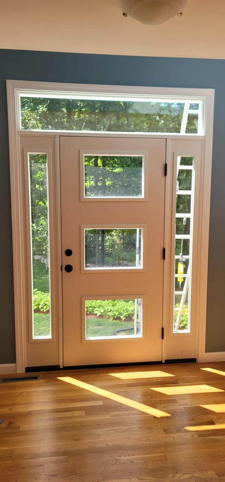 A front entrance of a house leads up to a beautiful wooden front door.