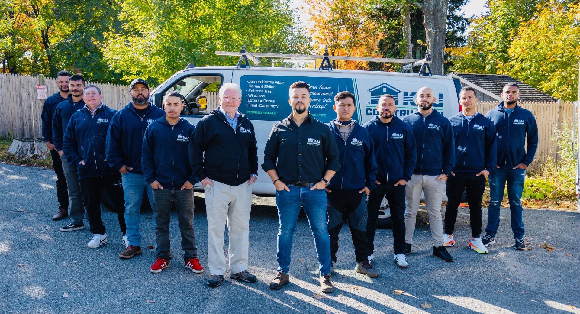 A group of men are posing for a picture in front of a van