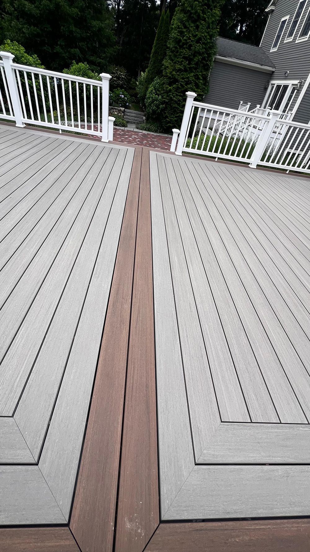 Deck with a dark wood inlay, surrounded by white railings.