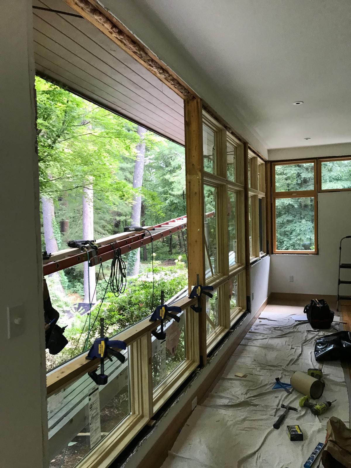 A room with a lot of windows and trees in the background