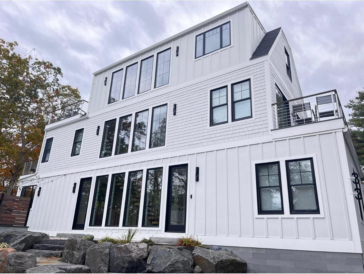 A large white house with a lot of windows and a balcony.