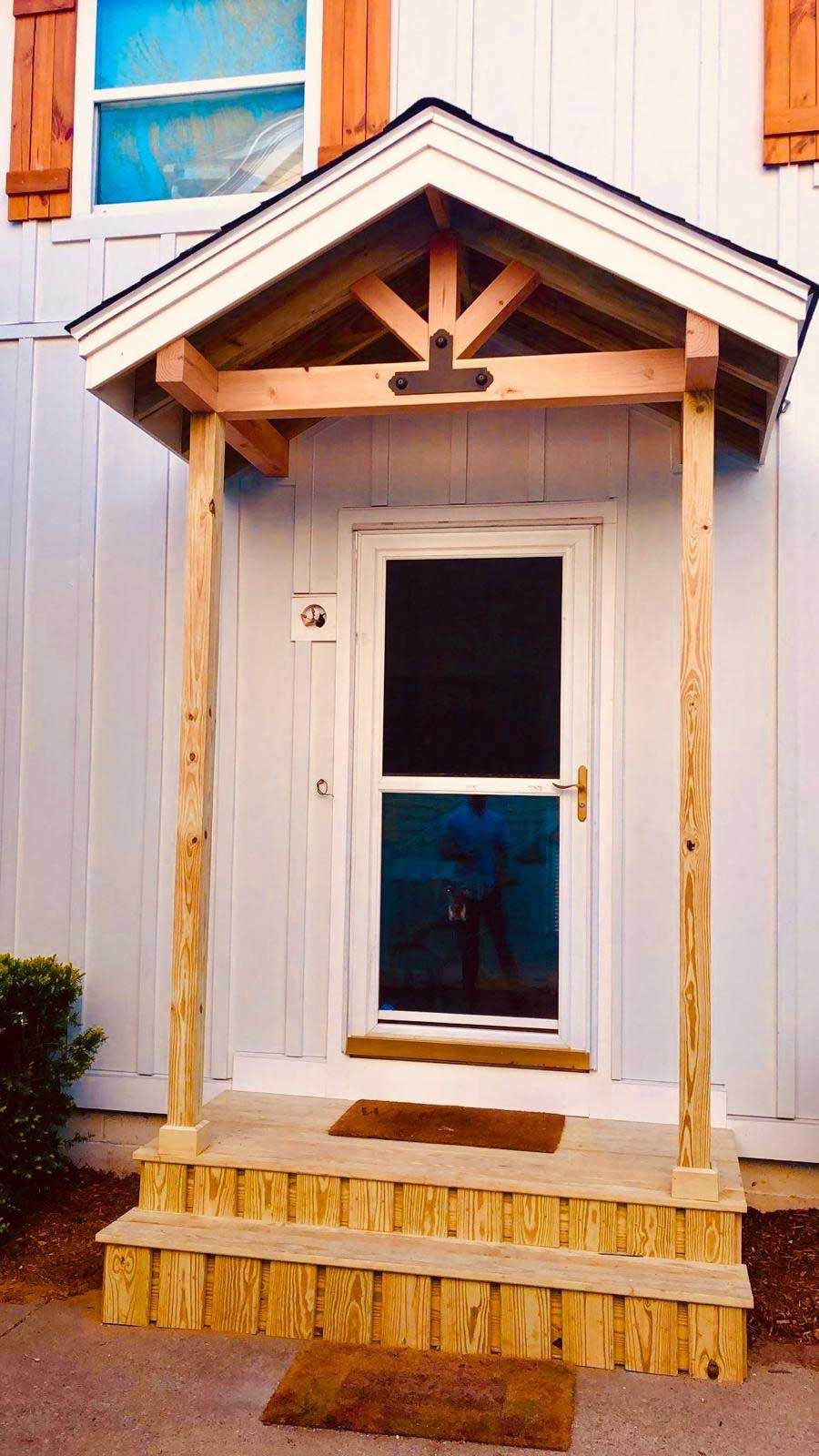 A white house with a wooden porch over the door