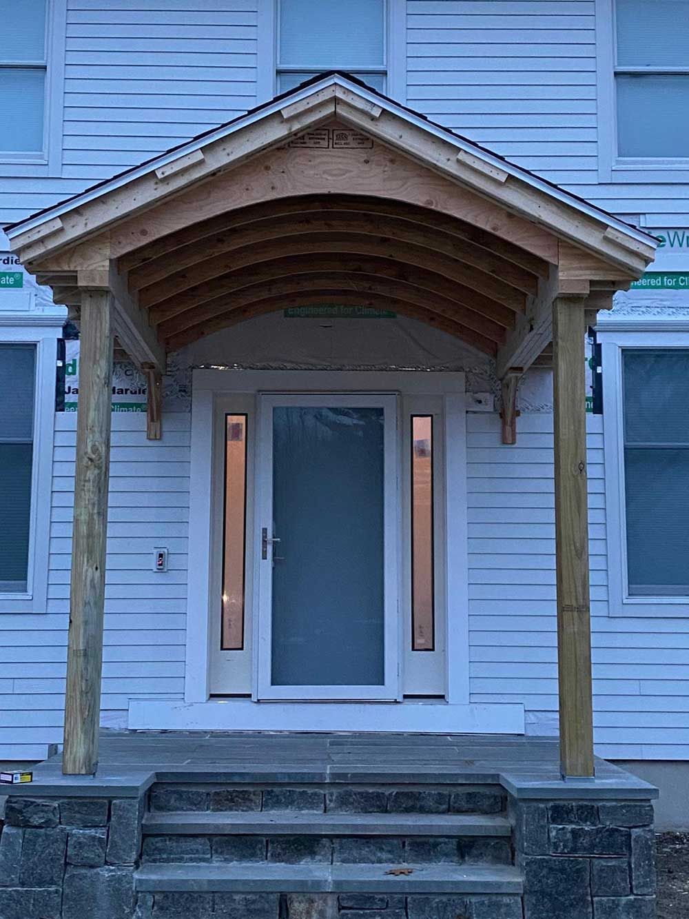 A white house with a wooden porch over the front door.