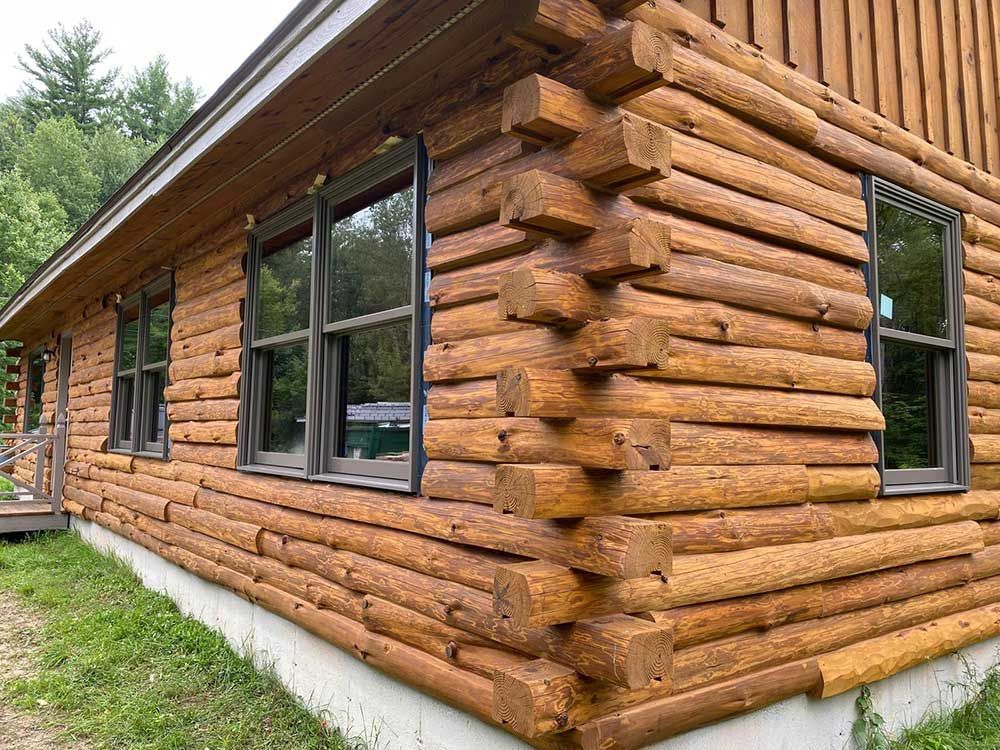 A log cabin with a lot of windows on the side of it.