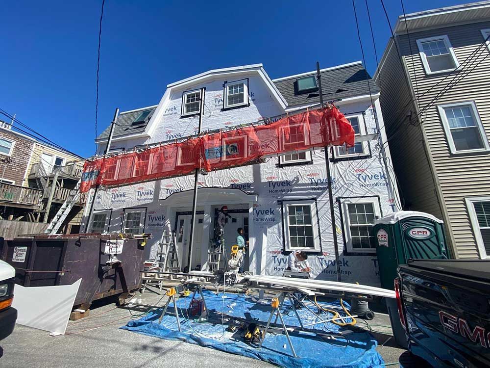 A large house is being remodeled on a sunny day.