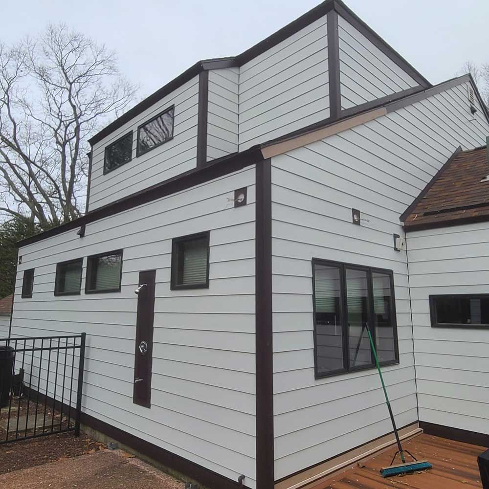 A white house with a broom on the side of it.