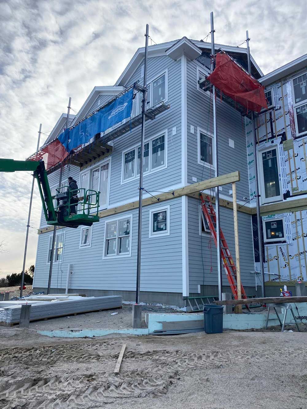 A large building is being built with scaffolding and a crane.