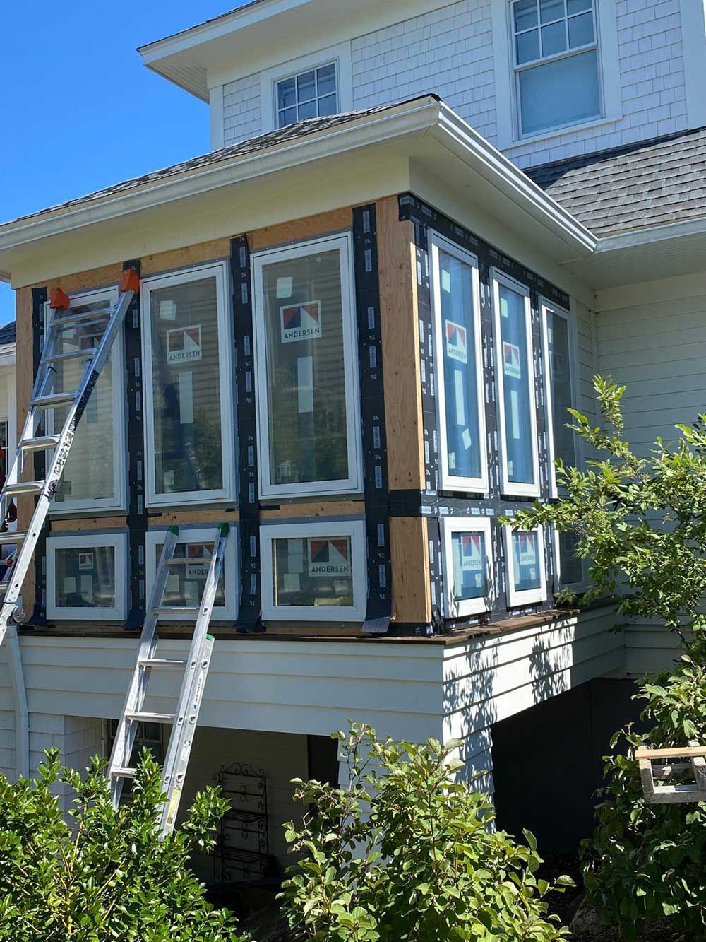 A white house with a ladder on the side of it