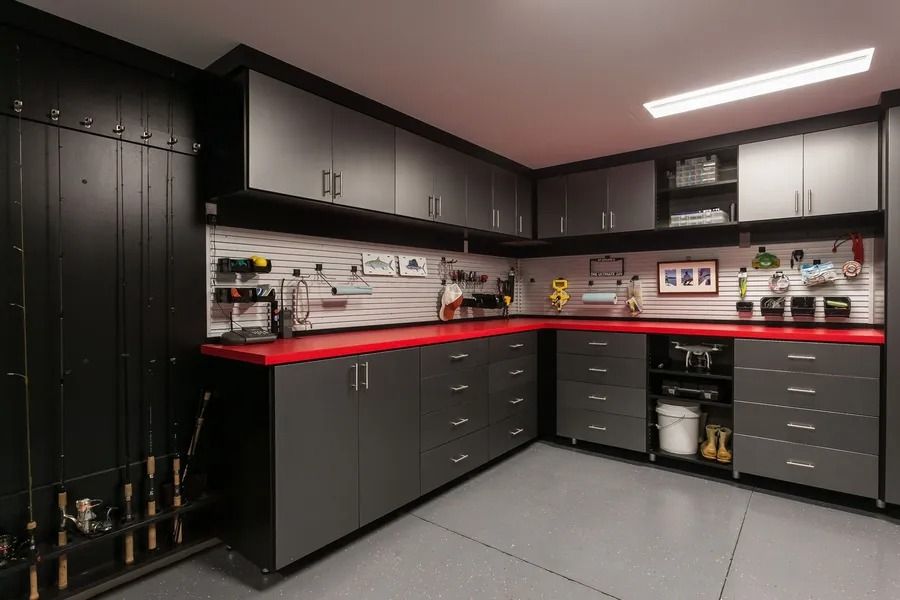 Garage with gray cabinets, red countertops, and black walls, organized for storage and work.