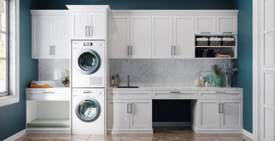 White laundry room with stacked washer/dryer, cabinets, countertop, and blue wall.