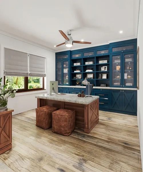 Home office with a wooden floor, blue cabinets, and a wooden desk.