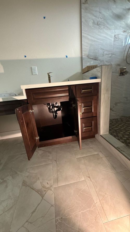 Damaged wooden cabinet with a broken open door in an unfinished room with tiled floor