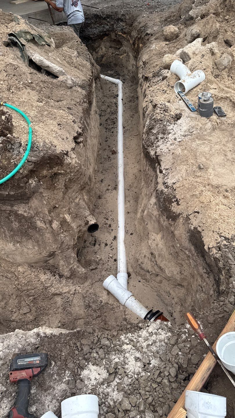 PVC pipe laid in a dirt trench during plumbing installation
