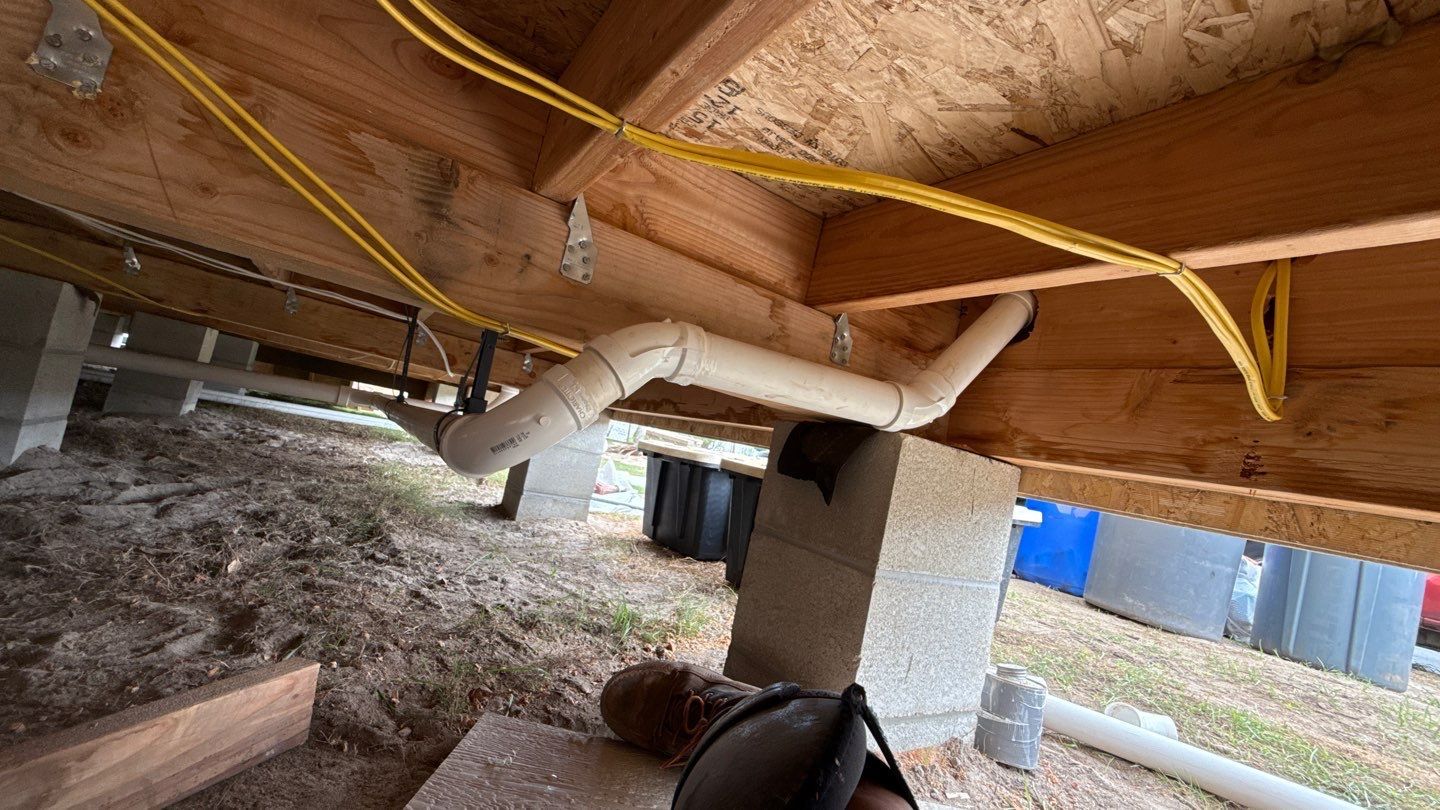 Crawlspace under a house with insulation, ductwork, a concrete support column, and hanging yellow cables
