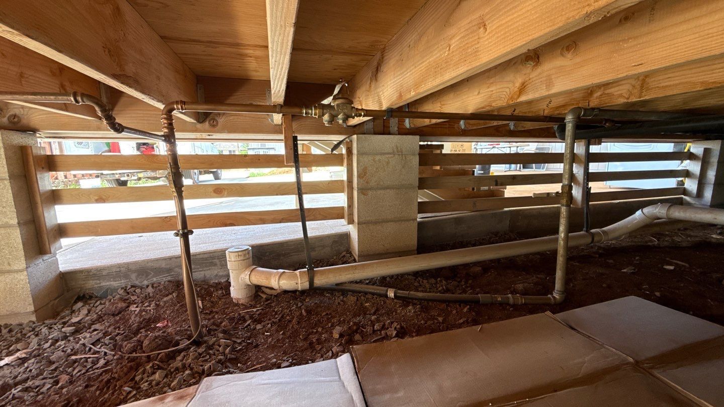 Interior of a wooden barn loft with slatted walls, hay, and stacked boards along the side.
