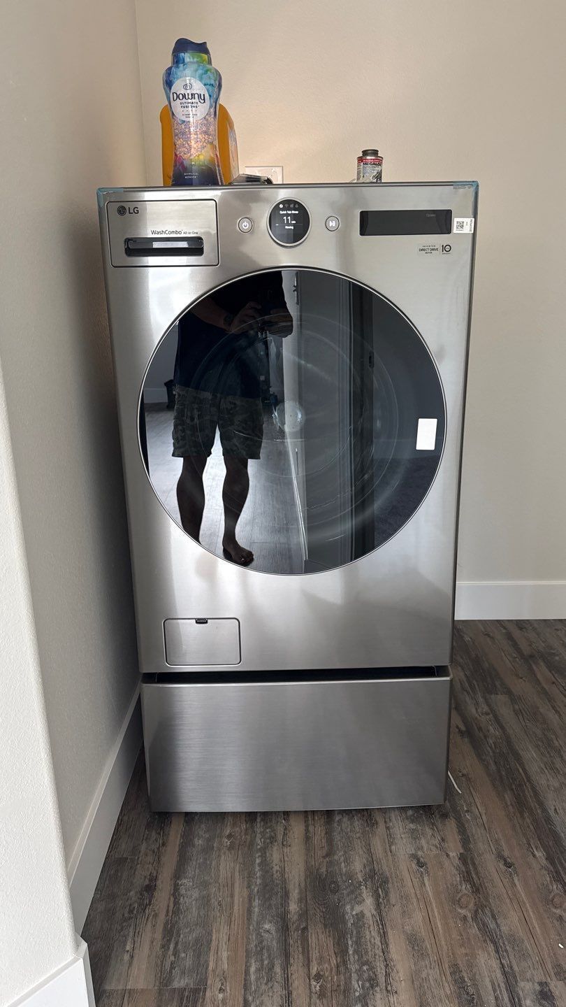 Front-loading dryer in a room, with a small figurine on top.