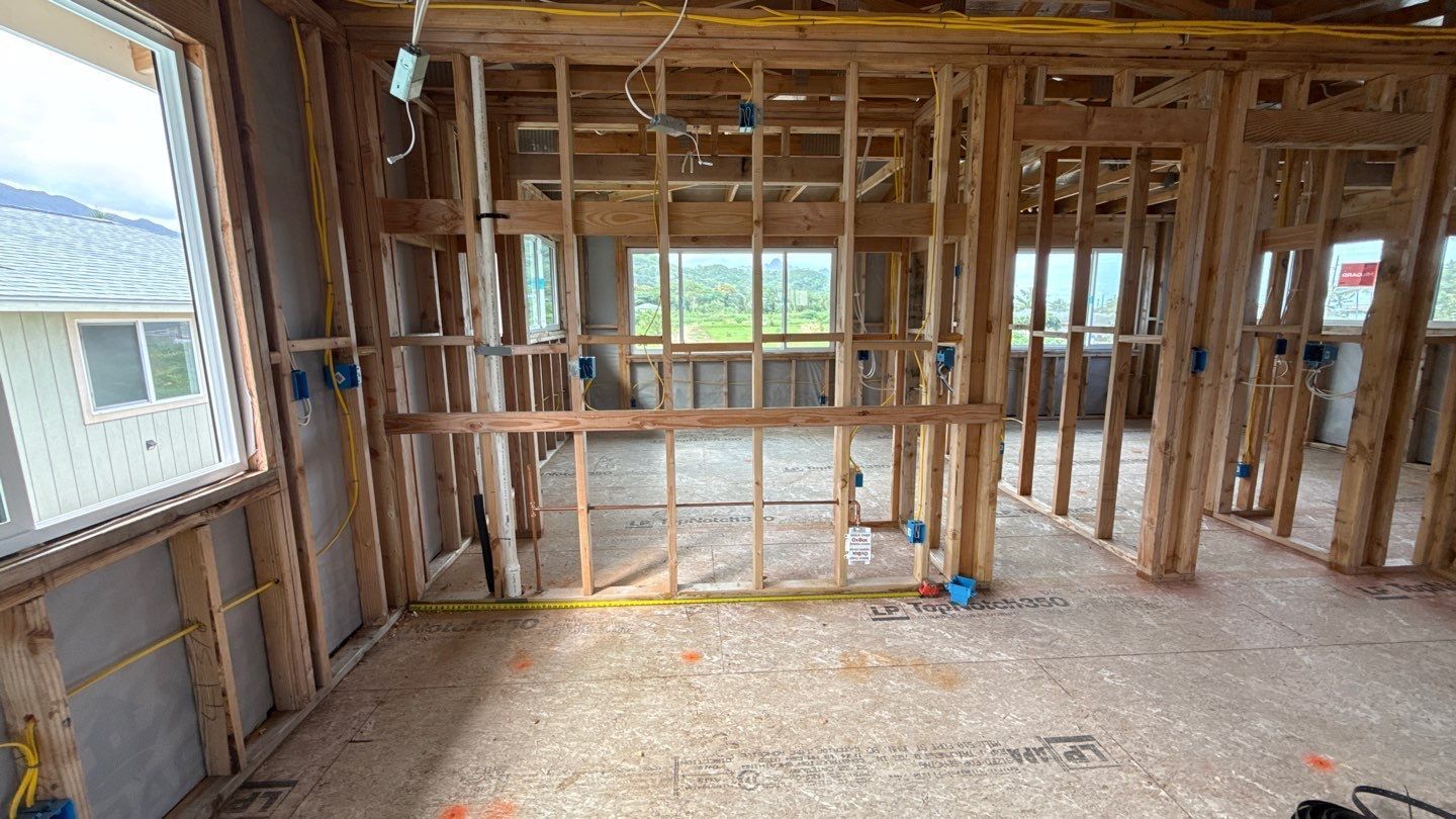 Interior of a house under construction with exposed wooden framing and unfinished walls.