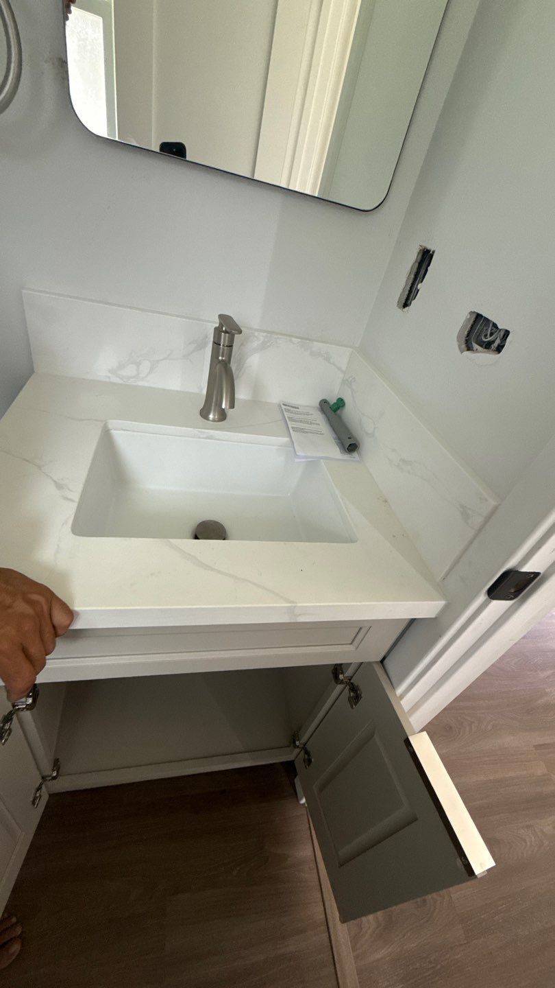 Bathroom vanity with white sink, mirror, and open cabinet below in a modern interior