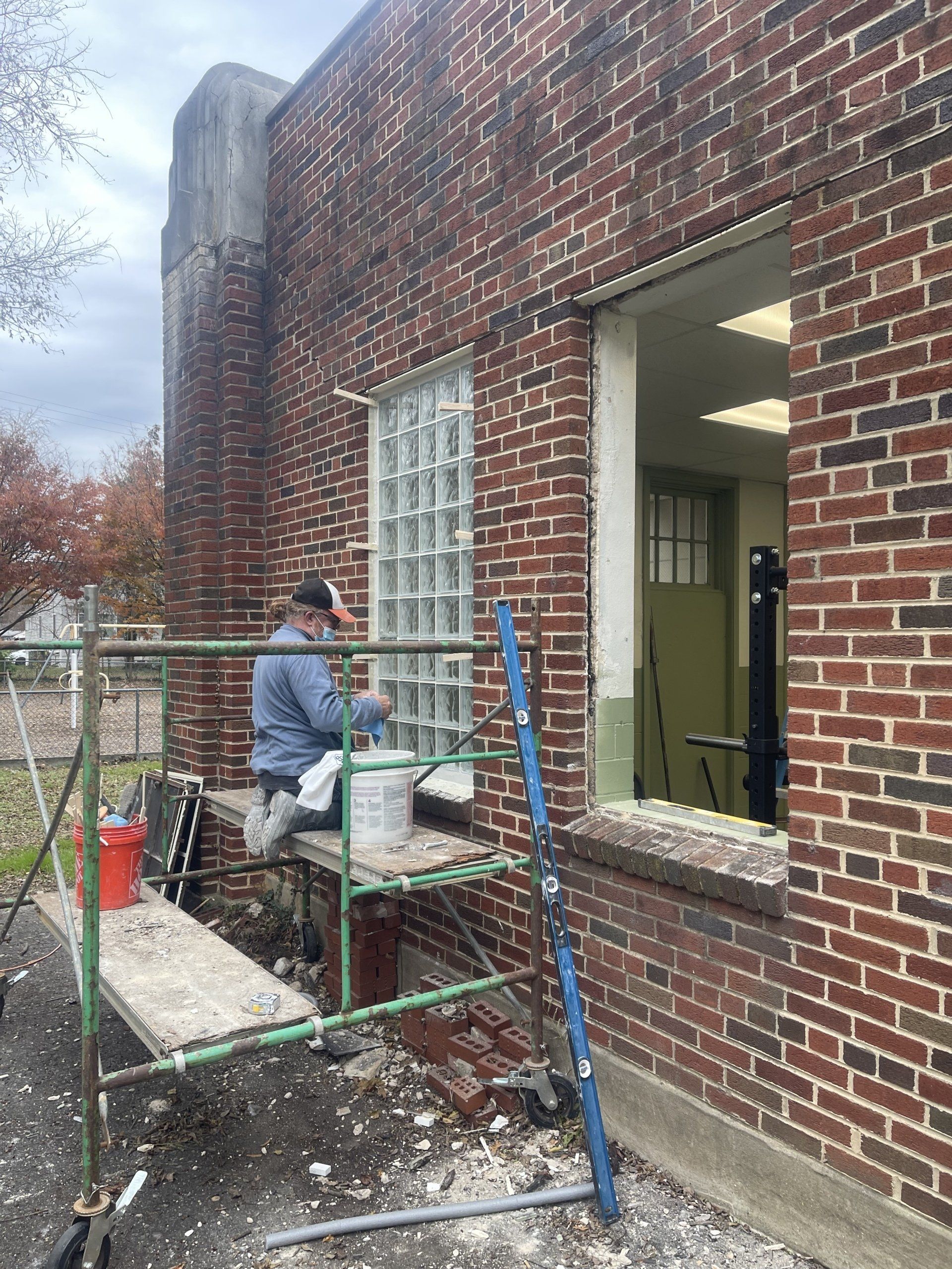 A man installing a glass block window