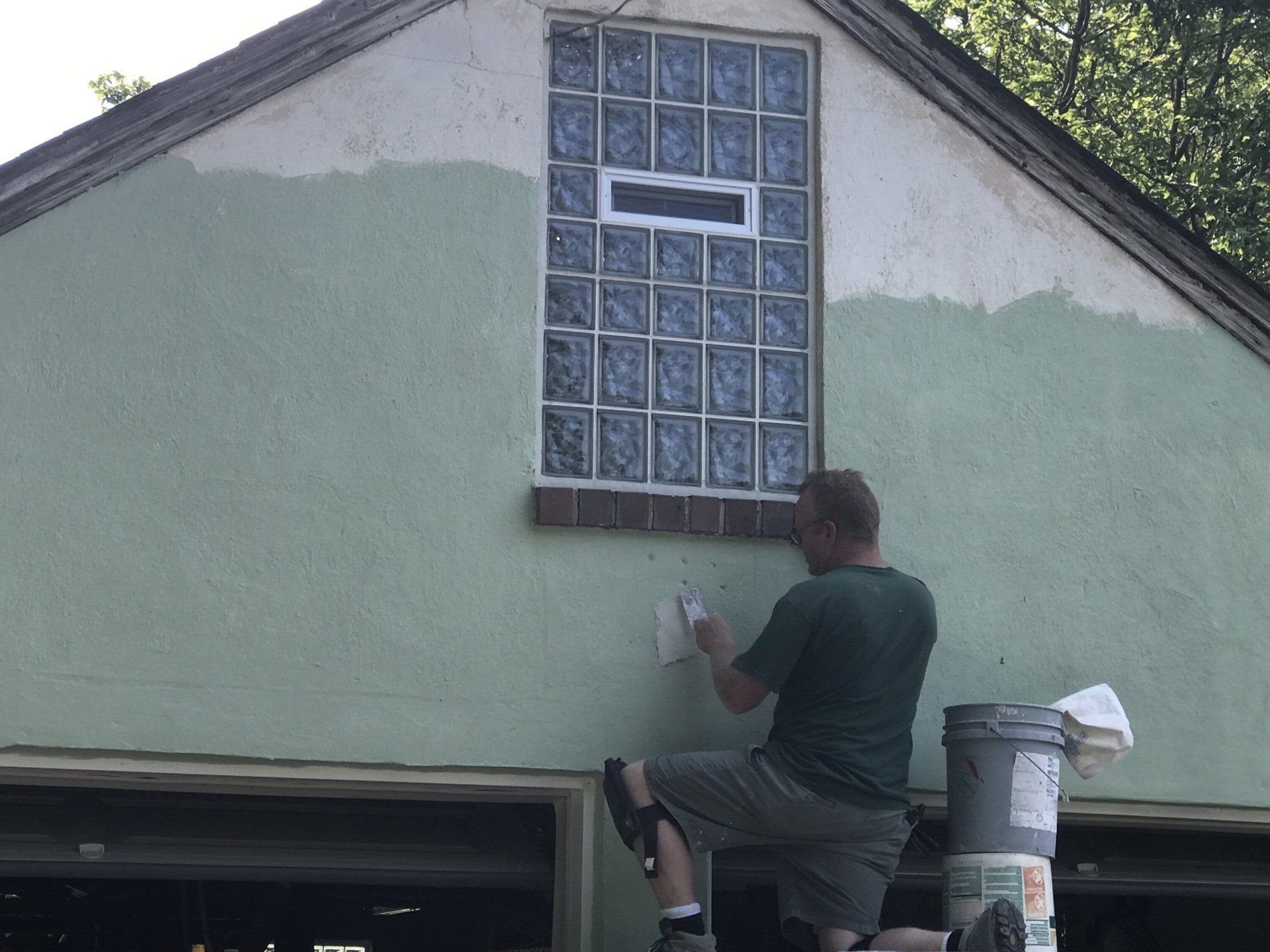 A man finishing up the glass block window installation