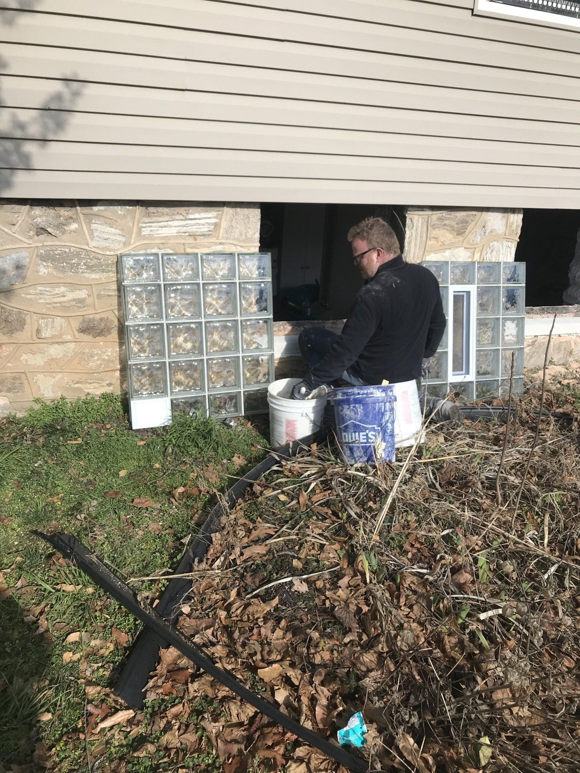 A man preparing an old window for new glass block installation